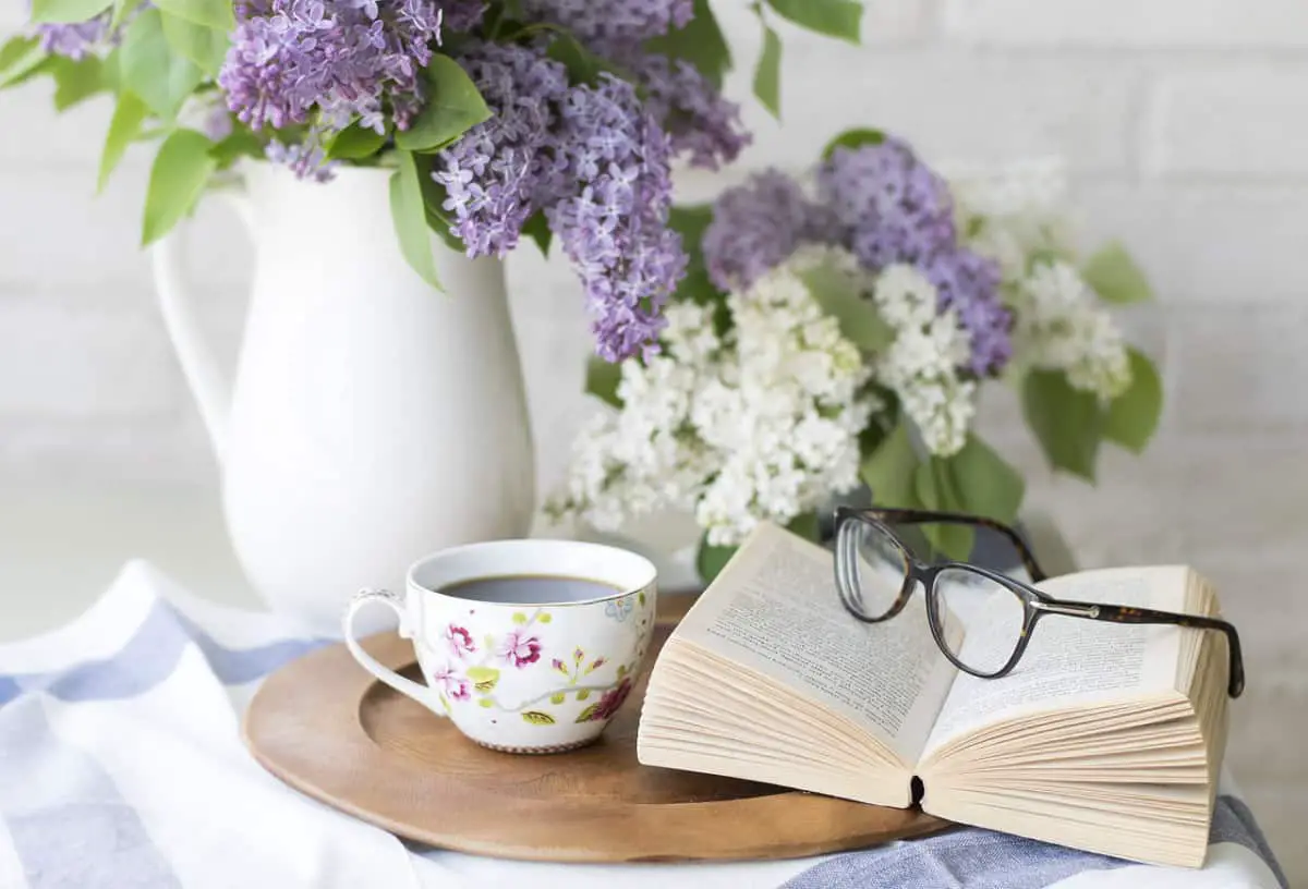lilacs in pitcher, books on table